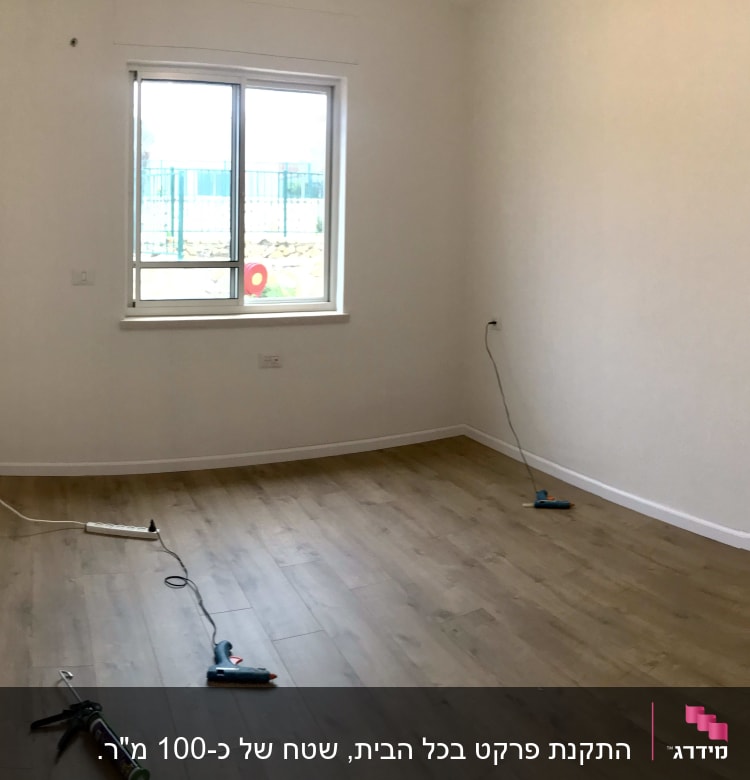 חדר עם פרקט עץ וכלי עבודה על הרצפה